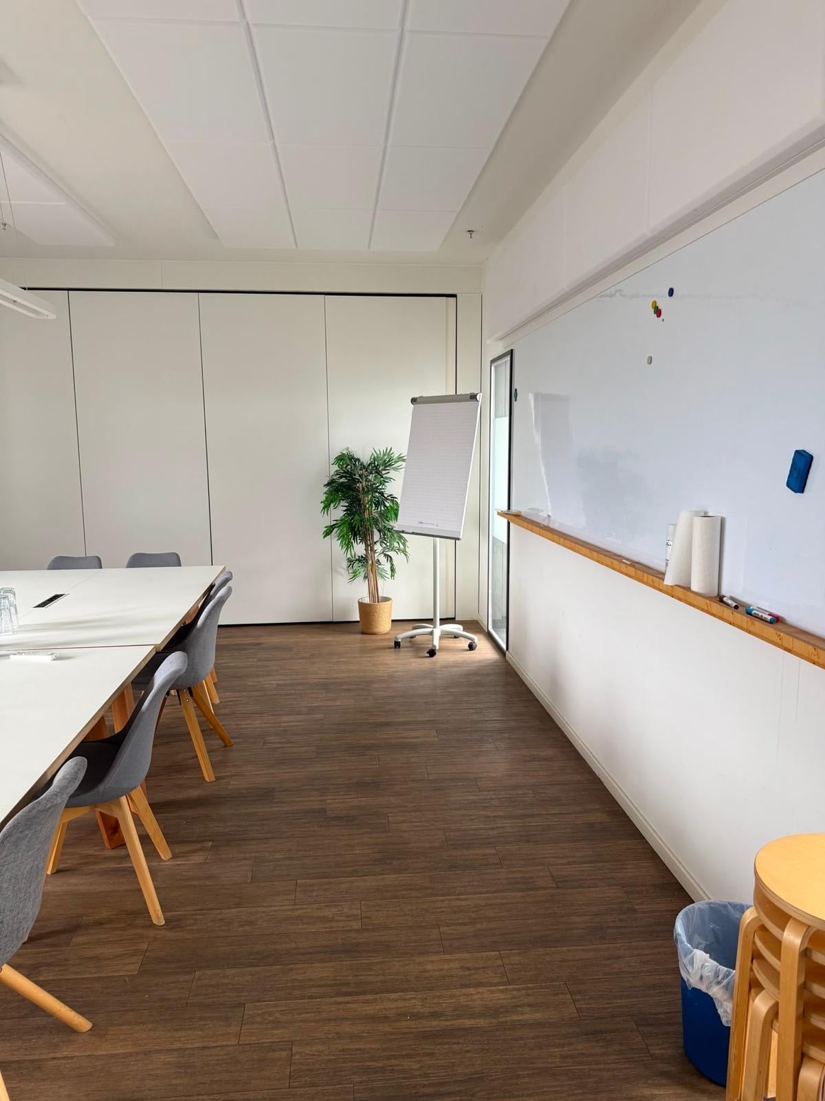 Meetingraum mit Whiteboard und Flipchart